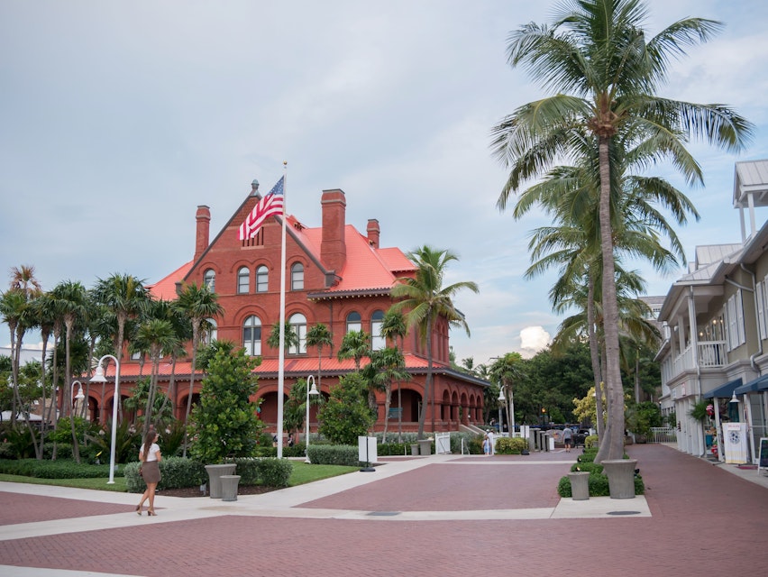 Key West, Florida, USA. August 2019. A girl is walking near Key West Art & Historical Society. The building houses the Museum of Art & History at the Custom House.
