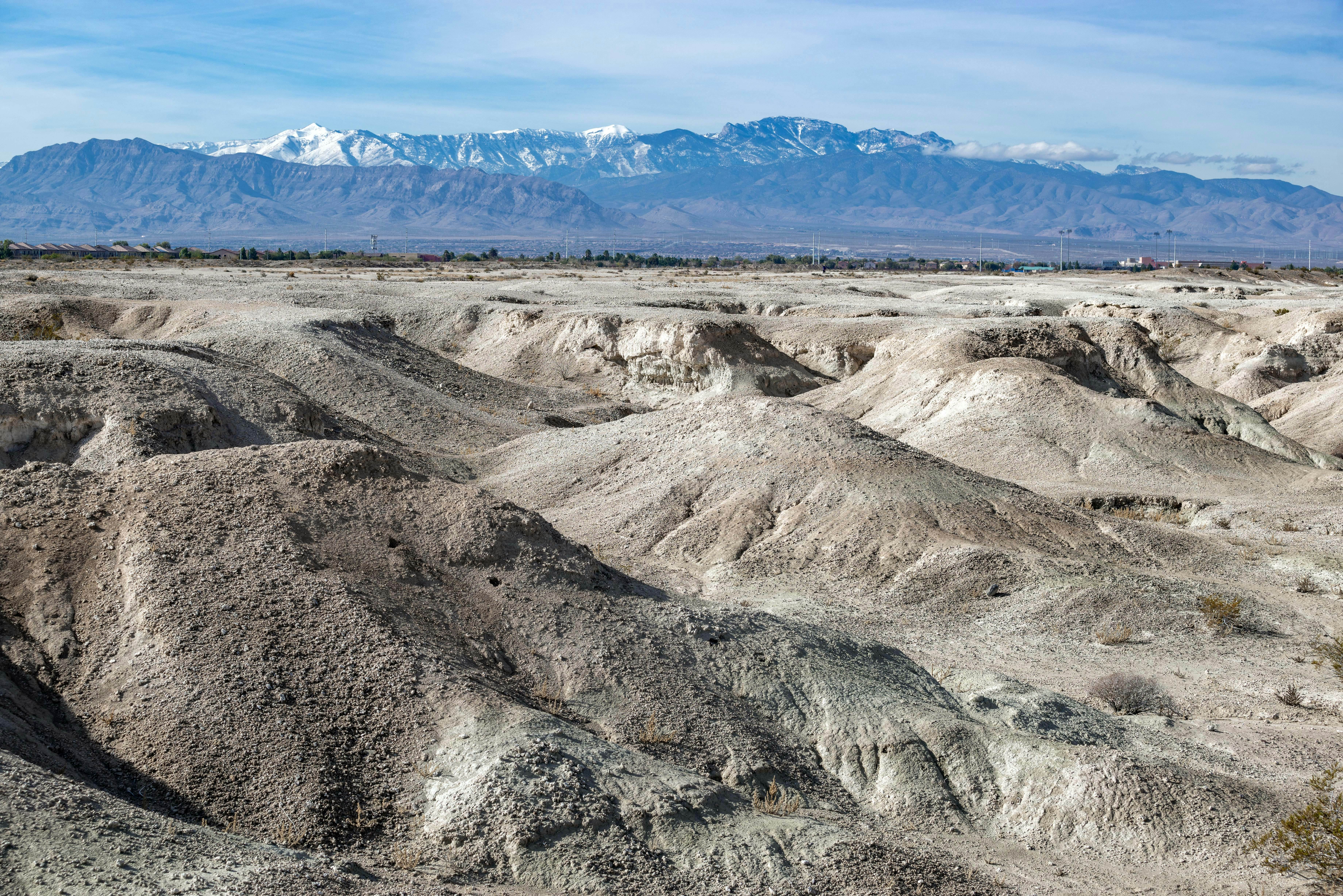 USA, Nevada, Clark County, Tule Fossil Beds National Monument: White gypsum hills at the urban fringe along the Las Vegas Wash with Mt. Charleston in the distance.; Shutterstock ID 1583690590; your: Bridget Brown; gl: 65050; netsuite: Online Editorial; full: POI Image Update
