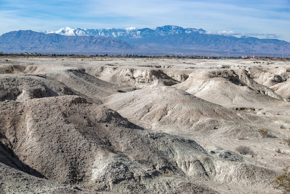 USA, Nevada, Clark County, Tule Fossil Beds National Monument: White gypsum hills at the urban fringe along the Las Vegas Wash with Mt. Charleston in the distance.; Shutterstock ID 1583690590; your: Bridget Brown; gl: 65050; netsuite: Online Editorial; full: POI Image Update