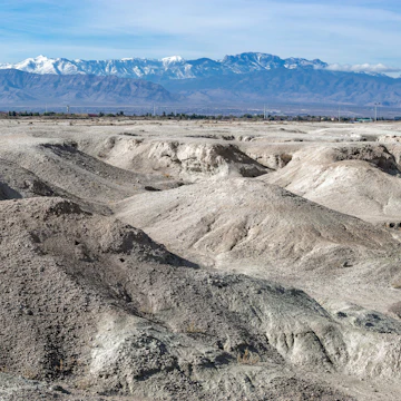 USA, Nevada, Clark County, Tule Fossil Beds National Monument: White gypsum hills at the urban fringe along the Las Vegas Wash with Mt. Charleston in the distance.; Shutterstock ID 1583690590; your: Bridget Brown; gl: 65050; netsuite: Online Editorial; full: POI Image Update