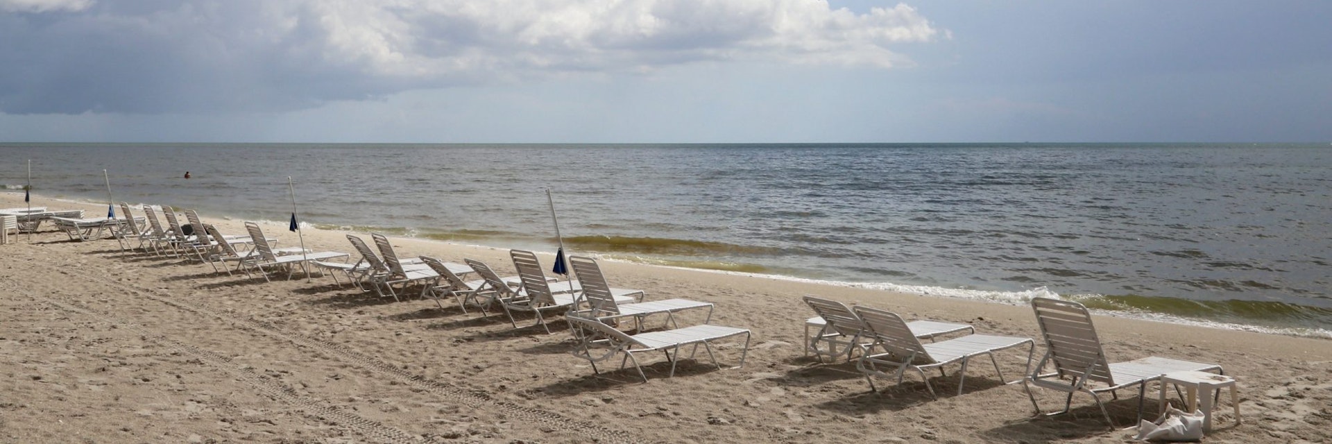 Row of lounge chairs on a scenic ocean beach, Delnor-Wiggins Pass State Park, Naples, Florida, USA - stock photo