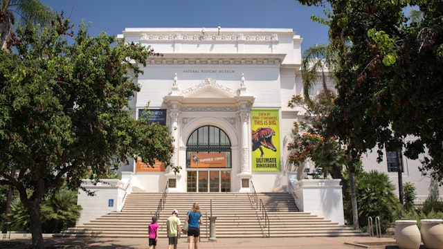 San Diego, California: Horizontal view of a mother and her two children going to the Natural History Museum entrance, Balboa Park