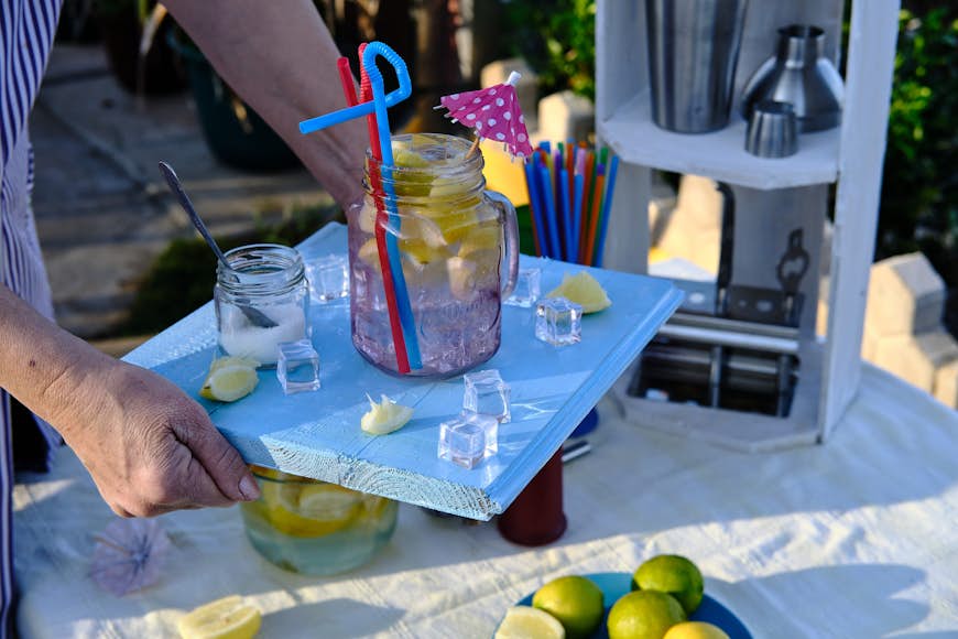 Servitrisen tar med en cocktail på sin blå träbricka