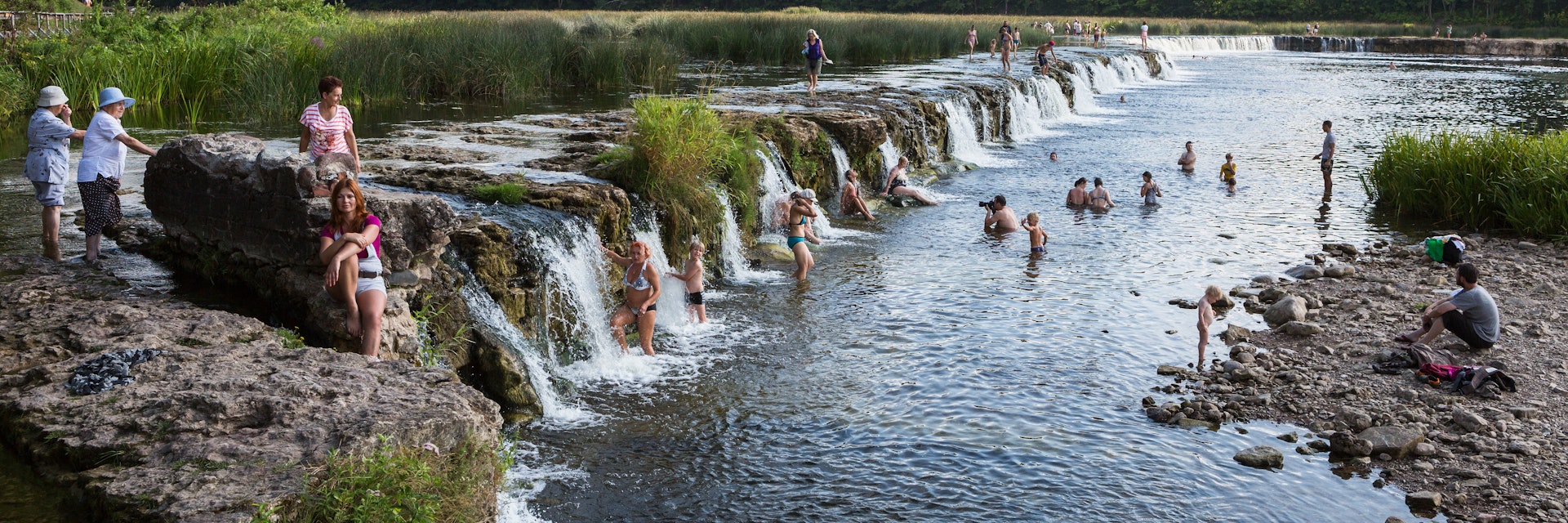 Kuldiga, Latvia - August 10, 2014: People are swimming by the waterfall. It's the longest waterfall in Europe.