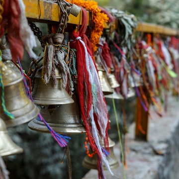metal bells hang on chains in a Hindu temple. Dakshinkali Temple in Pharping, Nepal.