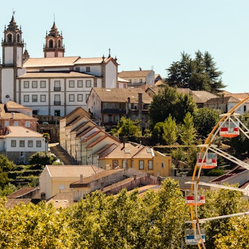 Viseu Cathedral in the background with the Ferris wheel at the São Mateus fair in the foreground