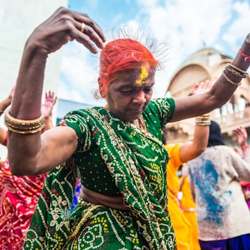 Barsana, India - March 10, 2014: Senior Indian woman celebrates Holi dancing in Radha Rani Temple in Barsana Village.