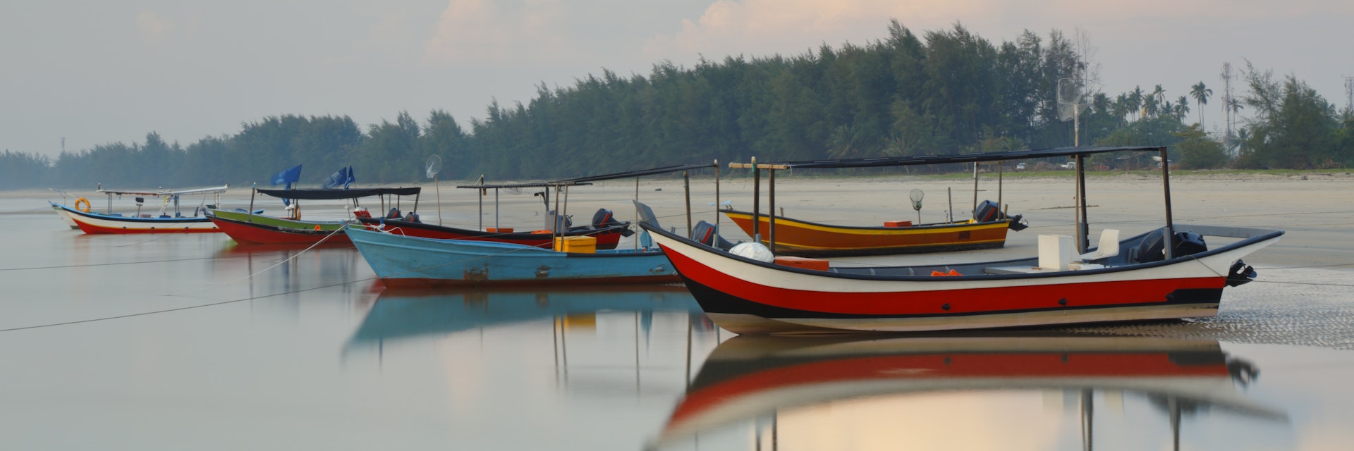 Local fishing boats lined along the shore. Cherating, Malaysia.