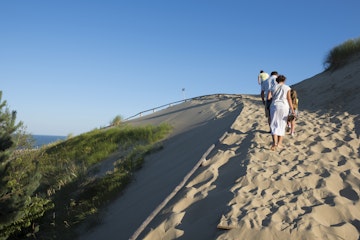 Nida, Lithuania - August 19, 2015: Late on a summer day, people walk up the Parnidis Dune outside Nida, a Lithuanian town on the Curonian Spit.