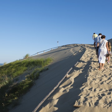 Nida, Lithuania - August 19, 2015: Late on a summer day, people walk up the Parnidis Dune outside Nida, a Lithuanian town on the Curonian Spit.