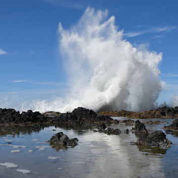 White water from a wave crashing against a rocky shoreline in the Cape Perpetua Scenic Area along the Oregon Coast.