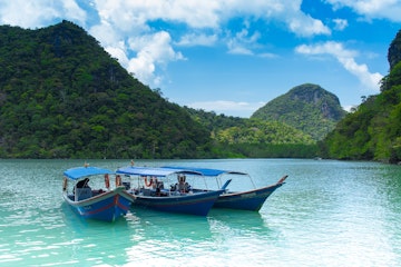 February 25, 2012: Three tourist boats in the water at Pregnant Maiden Island (Pulau Dayang).