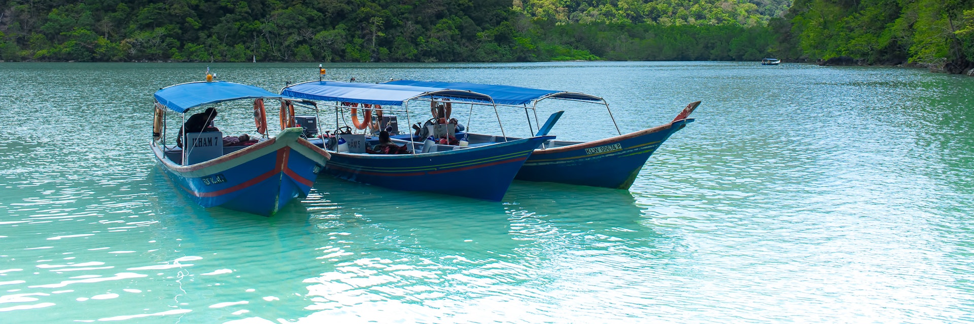 February 25, 2012: Three tourist boats in the water at Pregnant Maiden Island (Pulau Dayang).