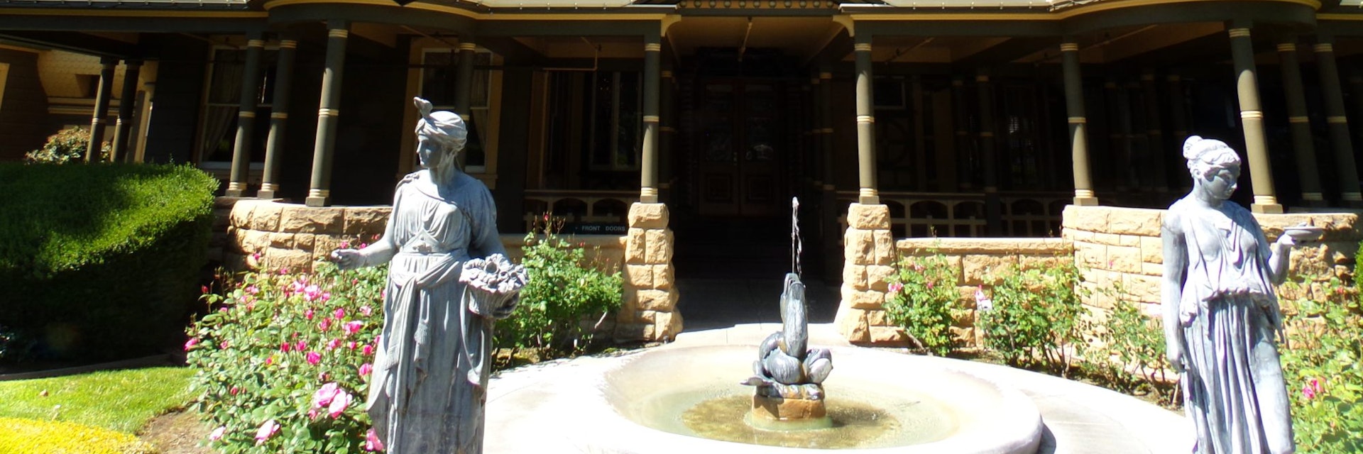 April 2, 2016: Exterior of the Winchester Mystery House with statues and a fountain.