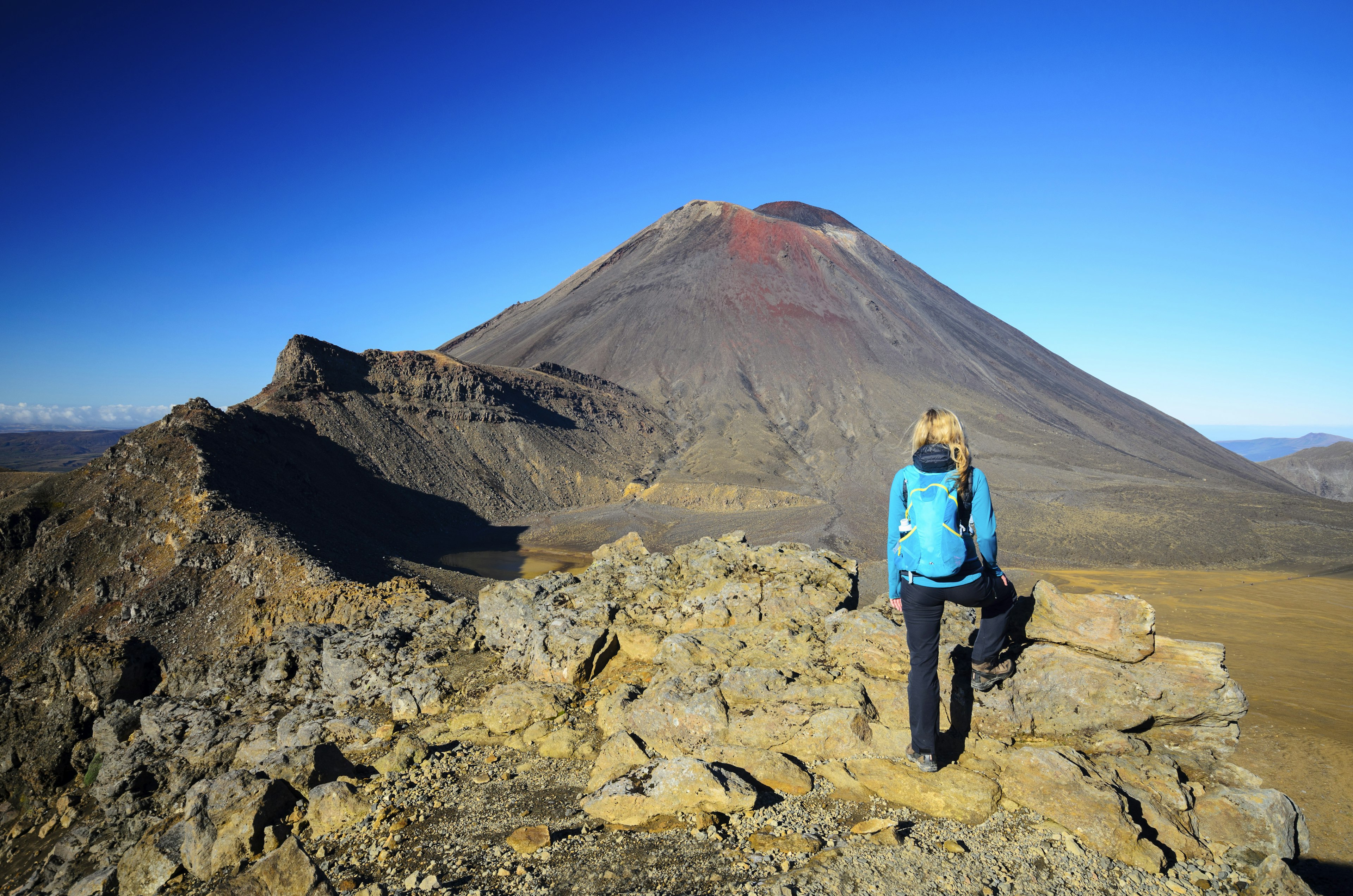 A female hiker pauses to look at Mount Ngauruhoe volcano on New Zealand's North Island