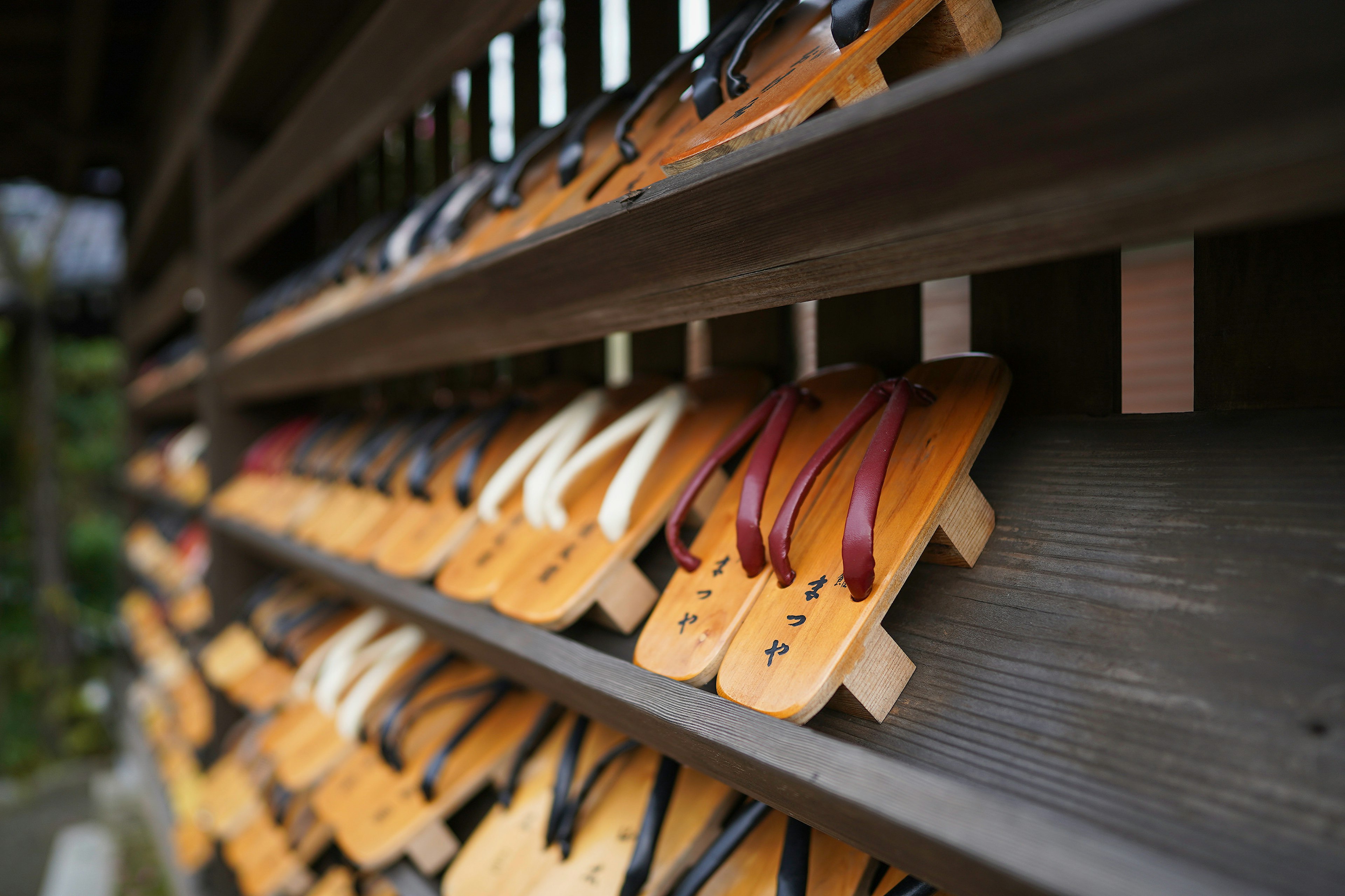 Close-up of Japanese traditional geta sandals with name of ryokan (hotel) written on them at Kinosaki Onsen