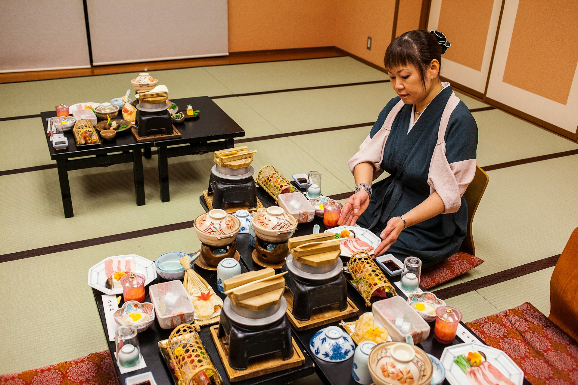 Waitress serving traditional food at Fujiya Ryokan accommodation in Kawayu Onsen on the Kumano Kodo