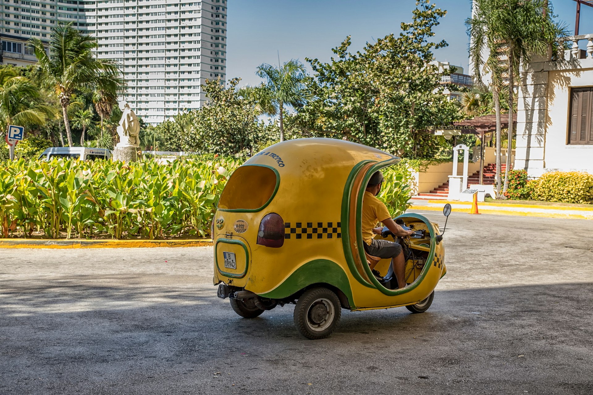 A yellow, coconut-shaped Cuban motorbike taxi (known as a Coco taxi), near the Hotel Nacional de Cuba in Havana