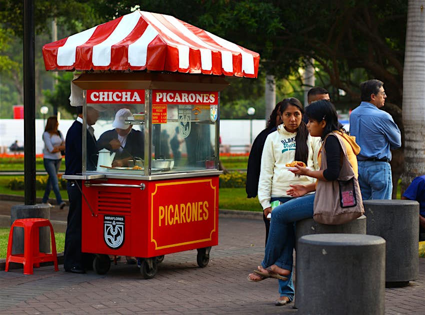 people selling and others eating Peruvian deep-fried sweets called Picarones in Parque Kennedy