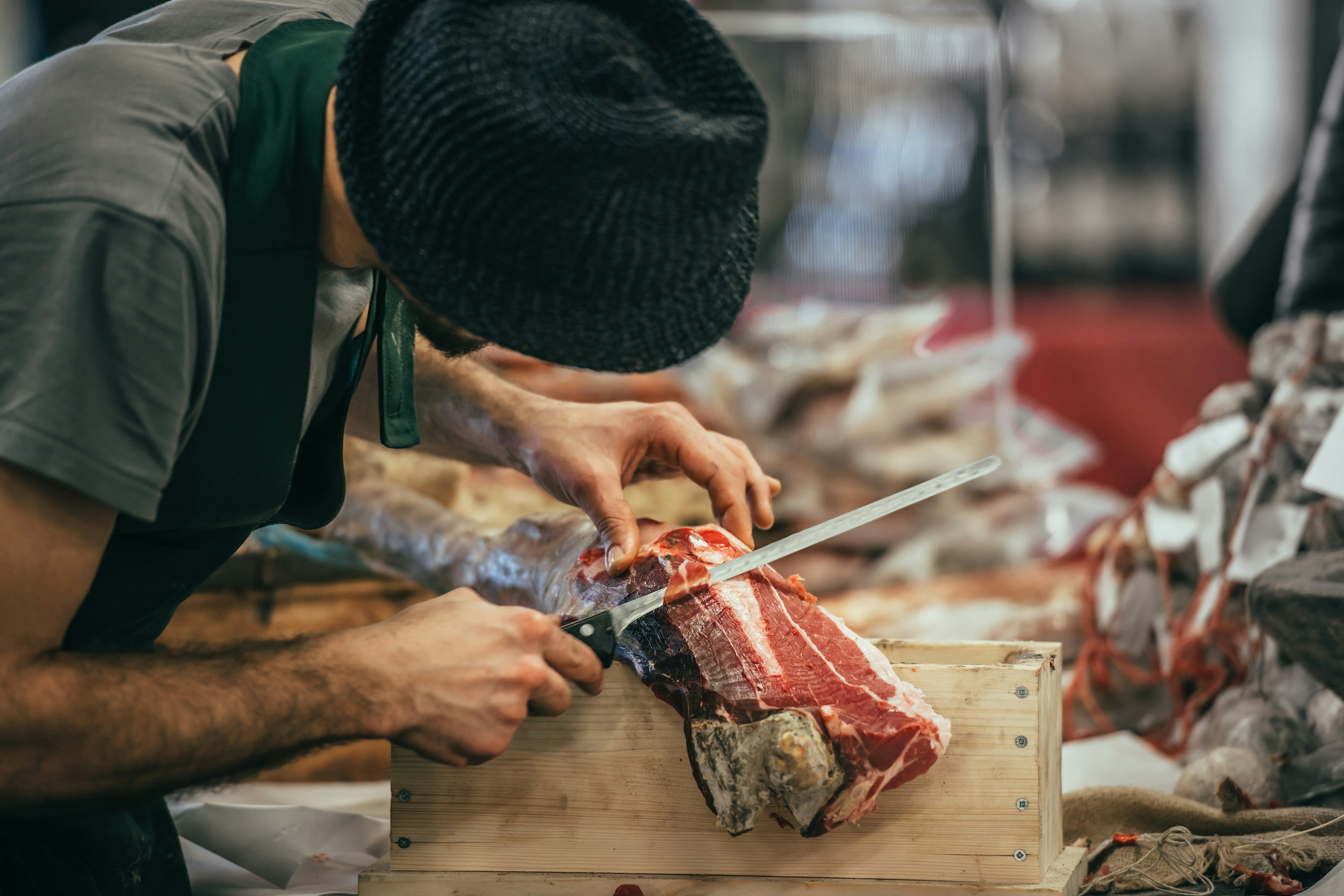 A man slices Italian dry-cured ham prosciutto