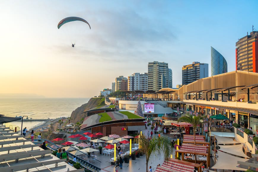 A paraglider flies over the Larcomar in Lima, Peru 