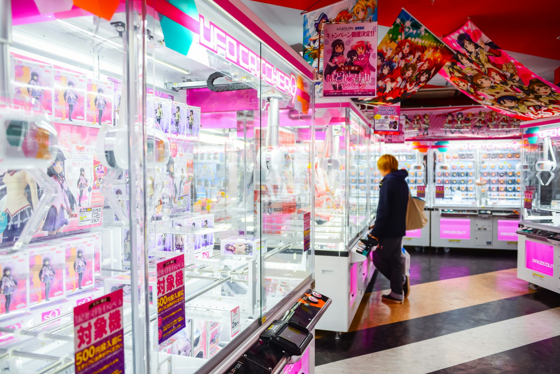 A person playing the claw machine in a games arcade in Tokyo