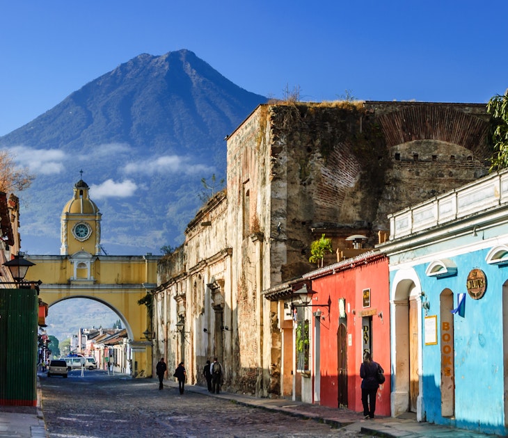 Antigua, Guatemala - March 11, 2012: Agua volcano behind Santa Catalina Arch (allowed nuns to pass to other side of convent without going outside) in colonial town & UNESCO World Heritage Site.