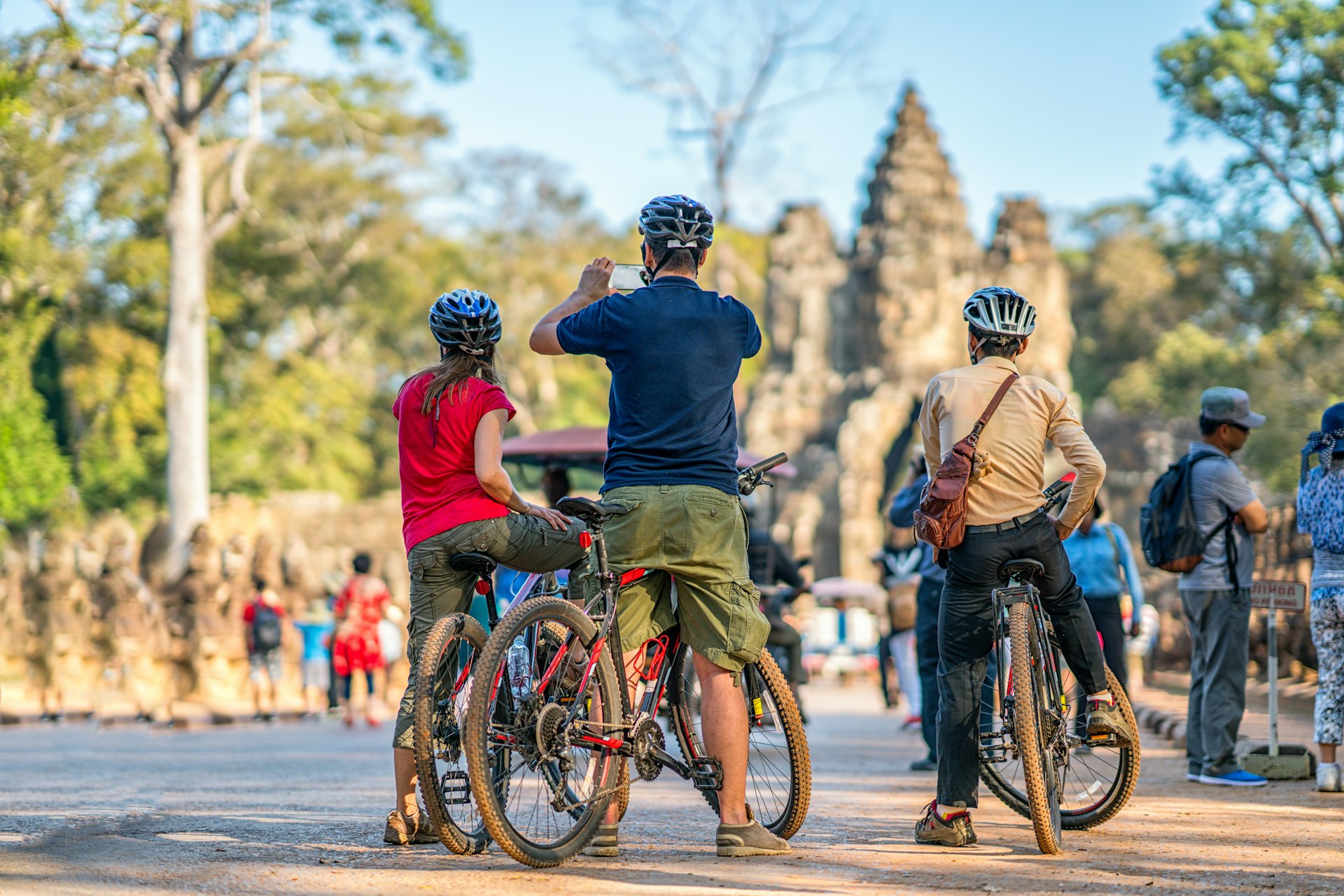 Travelers cycling at the gate of Angkor Thom, Cambodia