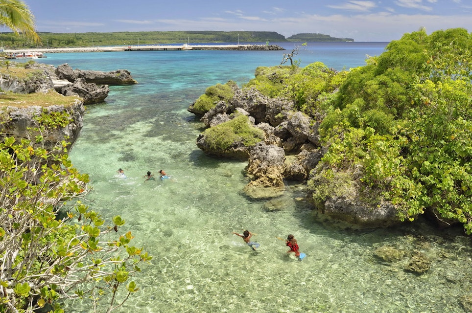 People swimming in a lagoon on Mare Island in New Caledonia.