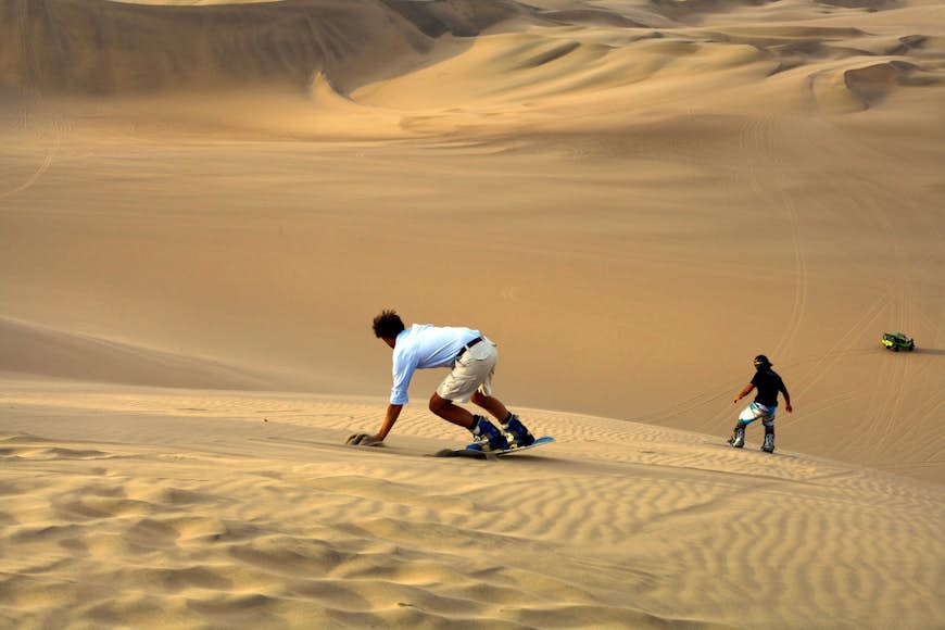 People sand-boarding in Peru