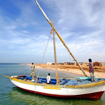 Coast of Banc d'Arguin National Park / Mauritania - photo taken December 01 / 2009 : boat with sails down and an fisher men onboard ; Shutterstock ID 1068303626; your: Erin Lenczycki; gl: 65050; netsuite: Online Editorial; full: Destination Update