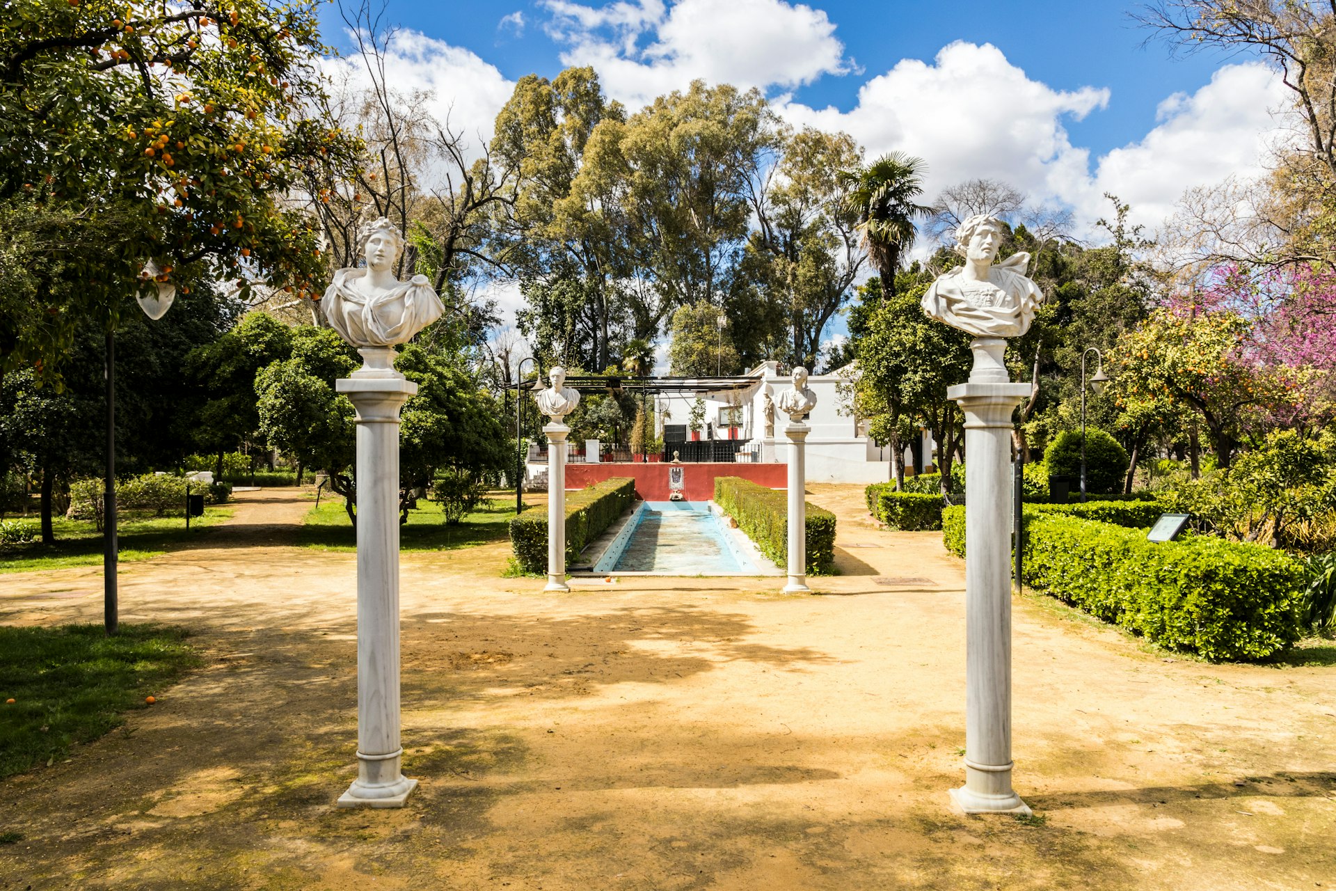 A pathway with marble busts on pillars in the Jardines de las Delicias, Sevilla, España