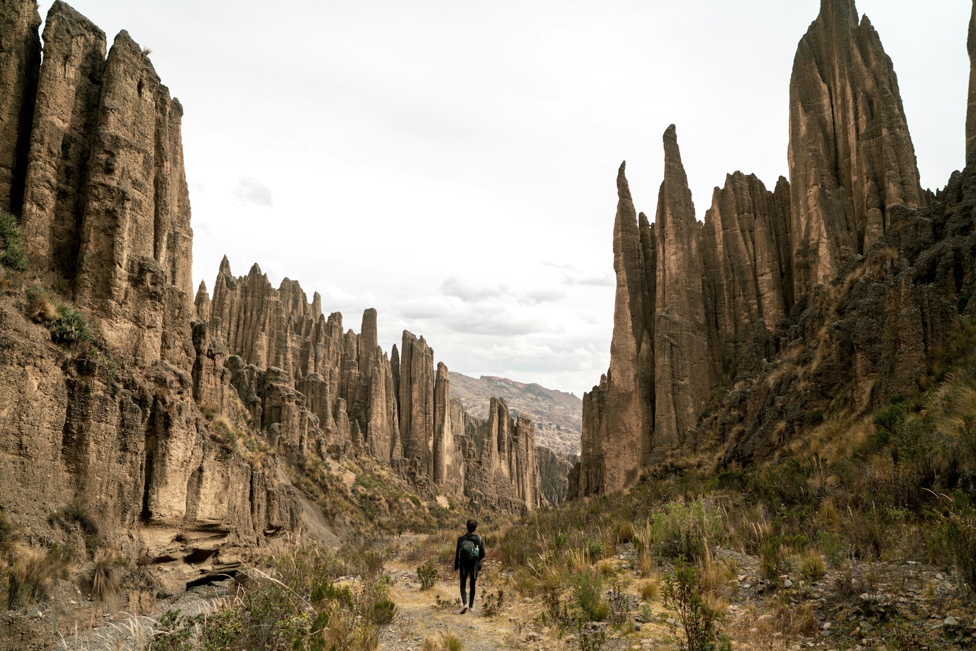 A man hikes through the towering rock formations in the Valle de las Ánimas, La Paz, Bolivia