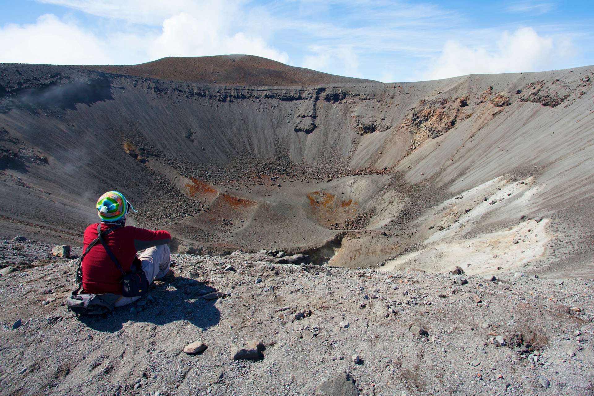 A hiker looking into the crater of the Purace volcano, Colombia
