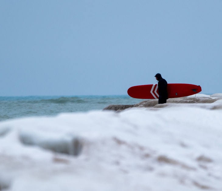 Sheboygan, Wisconsin, USA - January 10, 2018: Winter Surfing in Lake Michigan. The Malibu of the  Midwest freezes and doesn't stop visitors to the water for a new experience in fresh water surfing.; Shutterstock ID 1600796347; your: Brian Healy; gl: 65050; netsuite: Lonely Planet Online Editorial; full: Best beaches in Wisconsin