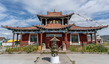 Mörön, Mongolia - August 17, 2019: Red wooden Buddhist temple with flags and statues in Mörön, Mongolia.; Shutterstock ID 1883394928; your: Erin Lenczycki; gl: 65050; netsuite: Online Editorial; full: Destination Update
