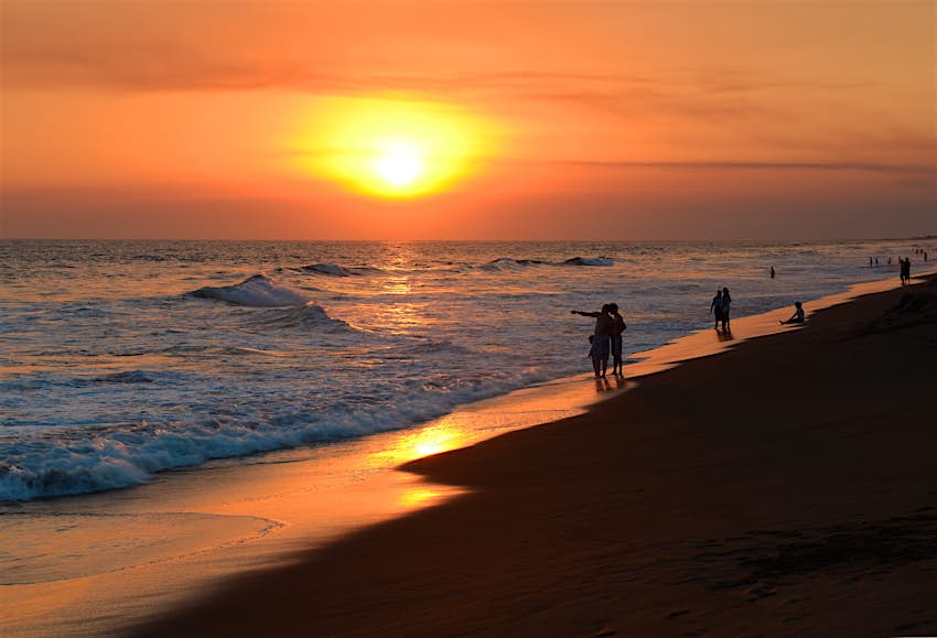 People walking along the beach in Monterrico, Guatemala, at sunset