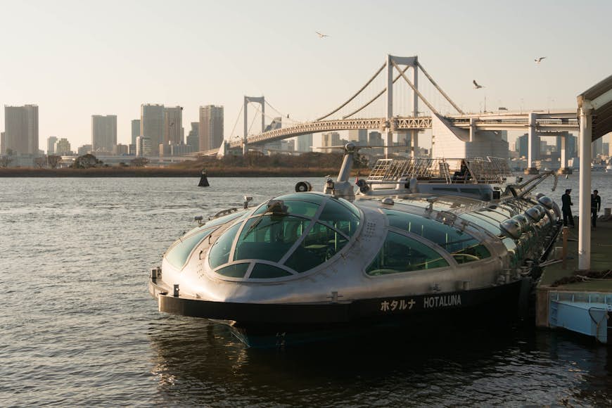 A water bus boat named Hotaluna at Odaiba Seaside Park in Tokyo in front of the Rainbow Bridge in the afternoon before sunset, Tokyo, Japan