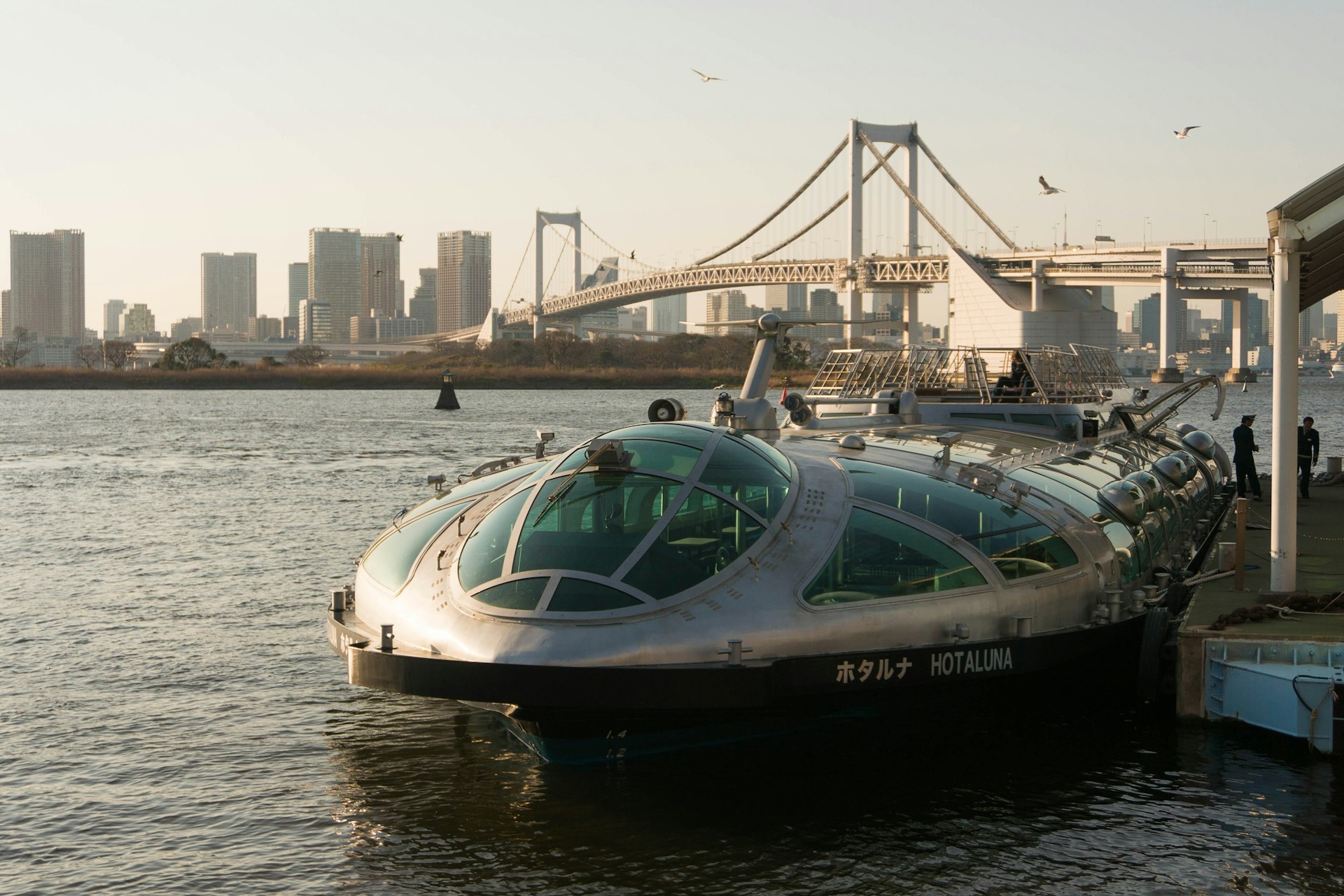  A water bus boat named Hotaluna at Odaiba Seaside Park in Tokyo in front of the Rainbow Bridge in the afternoon before sunset, Tokyo, Japan