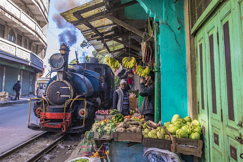 A Darjeeling toy train passing a market stand near Ghoom with only a few inches clearance