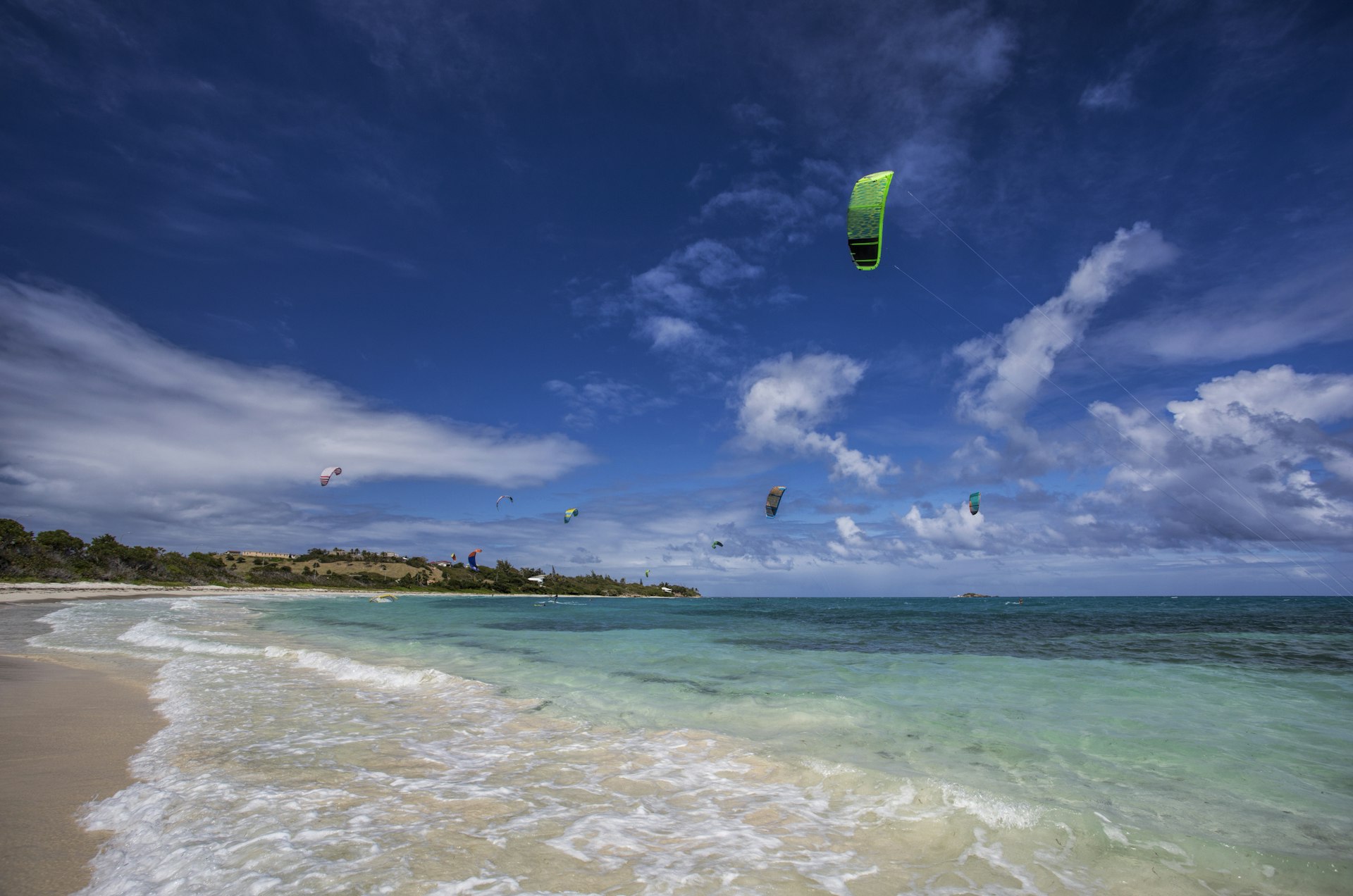 Kitesurfers soar above azure waters at Jabberwock Beach in Antigua