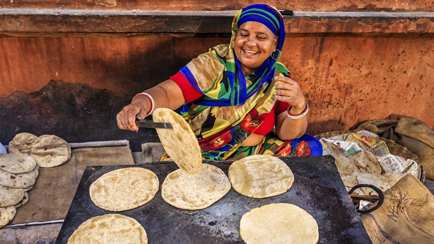 Indian street vendor preparing food - chapatti, flat bread, Jaipur - The Pink City, Rajasthan, India.  Jaipur is known as the Pink City, because of the color of the stone exclusively used for the construction of all the structures.