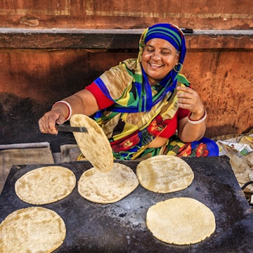 Indian street vendor preparing food - chapatti, flat bread, Jaipur - The Pink City, Rajasthan, India. Jaipur is known as the Pink City, because of the color of the stone exclusively used for the construction of all the structures.