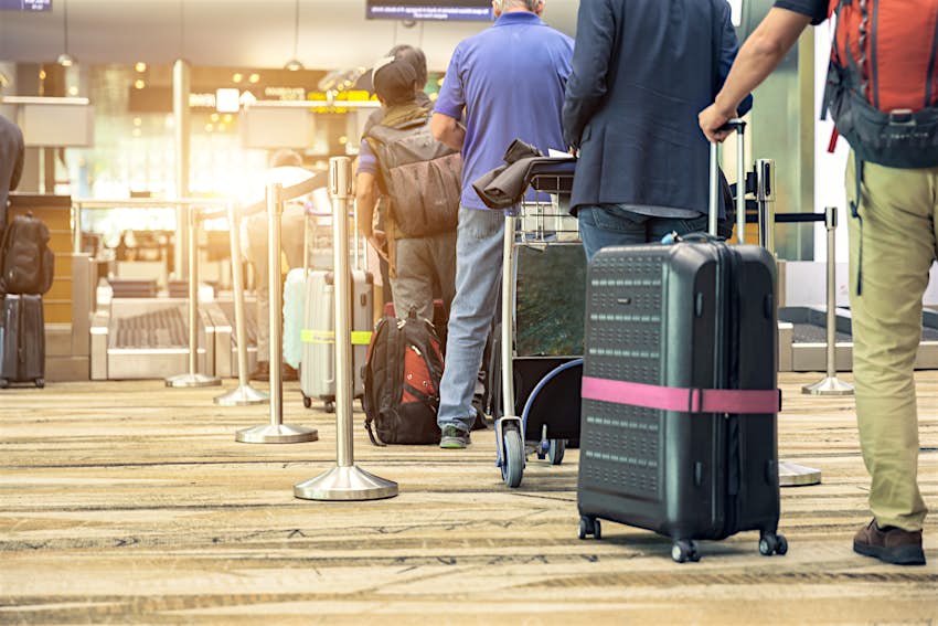 I passeggeri si sono messi in fila in aeroporto per il check-in dei bagagli.