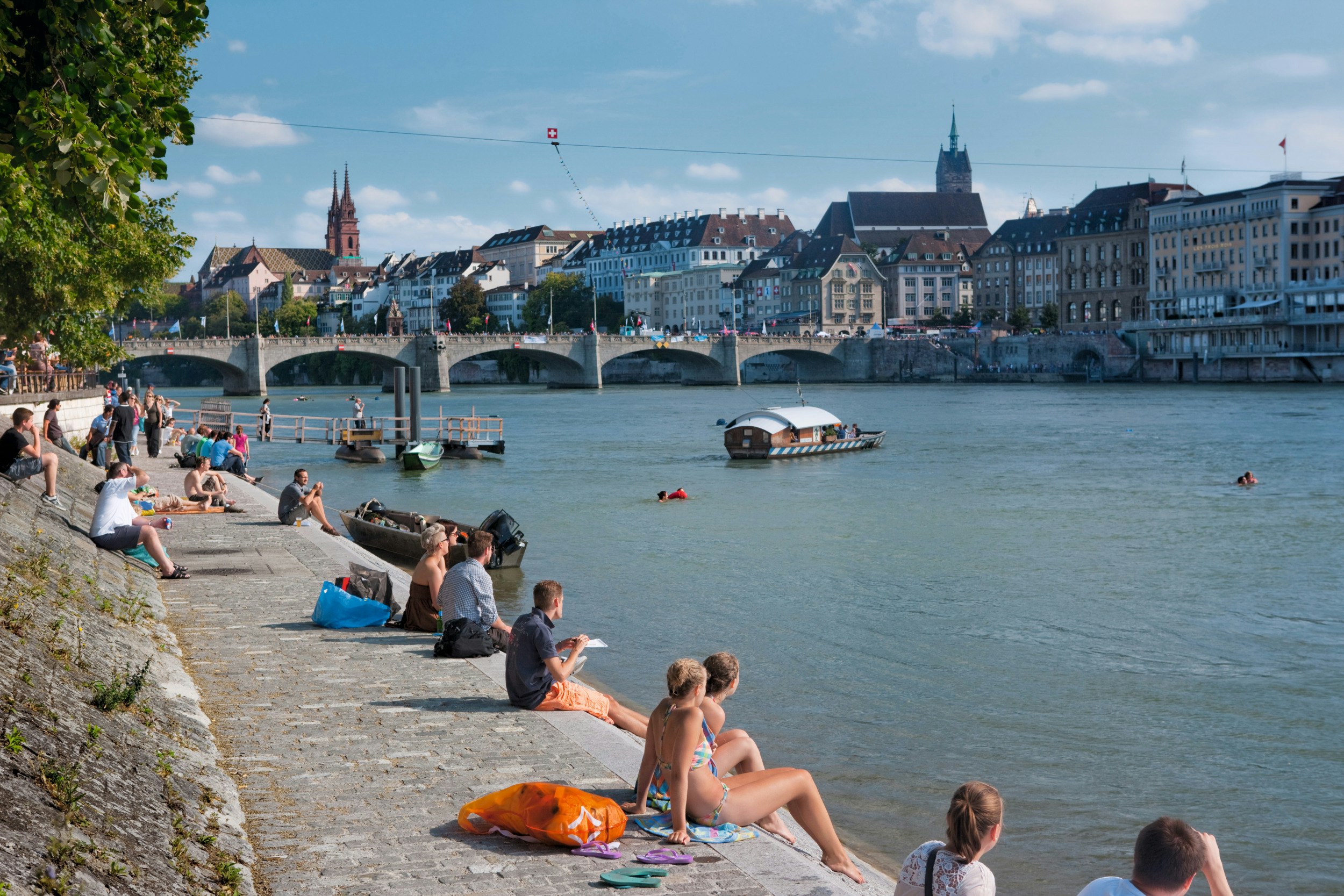 People enjoying the summer in the city on the banks of the Rhine in Base