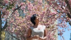 A woman enjoying the cherry blossom in a Toronto park in spring