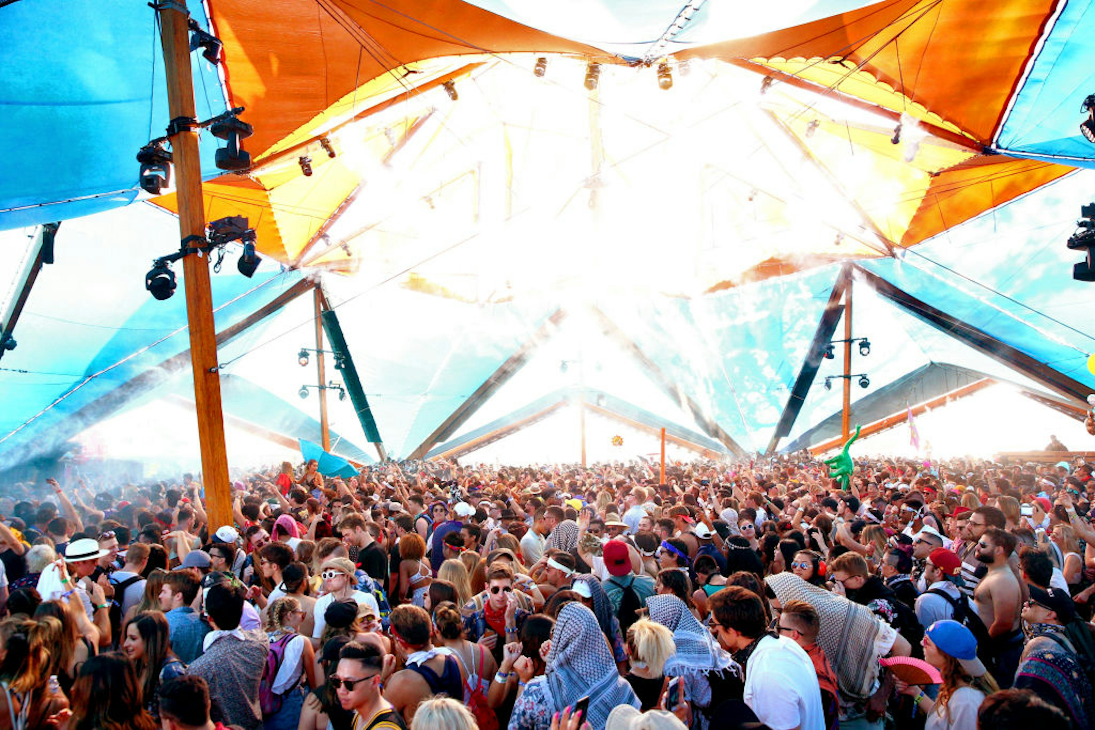 People dance inside a yellow and blue tent at the Coachella Valley Music And Arts Festival.