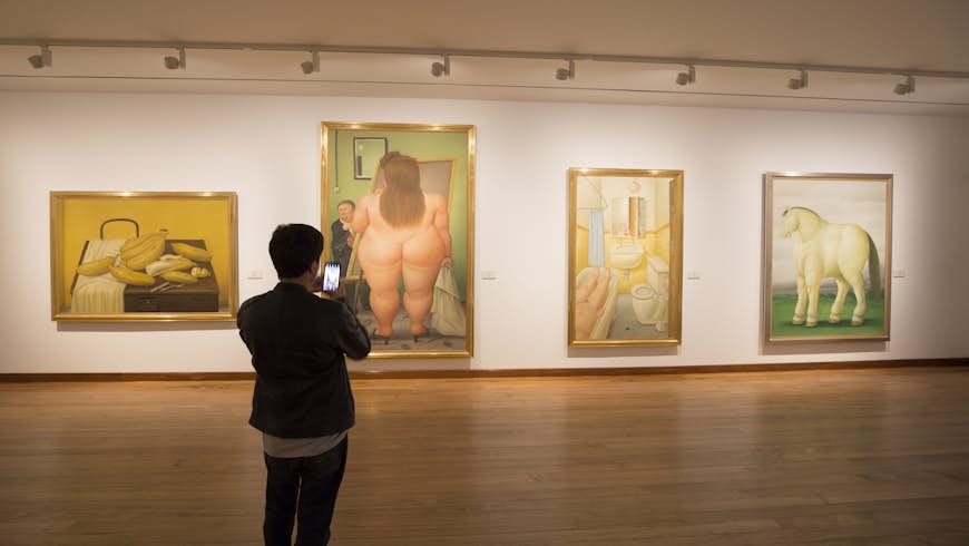 A man takes photos of works of art by Fernando Botero at the Museo Botero, Bogotá, Colombia, South American