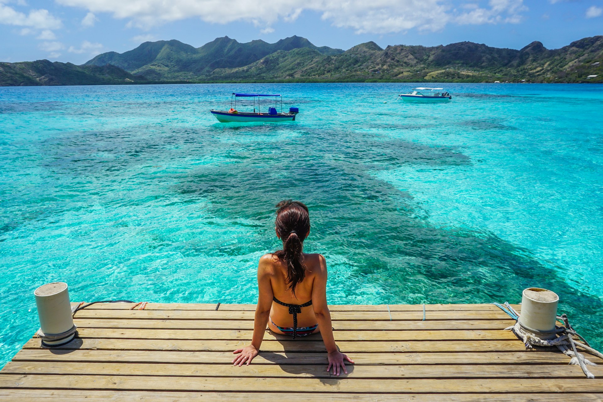 A woman sitting on dock, seen from behind, at Crab Cay (Cayo Cangrejo), Providence Island (Isla de Providencia), Colombia