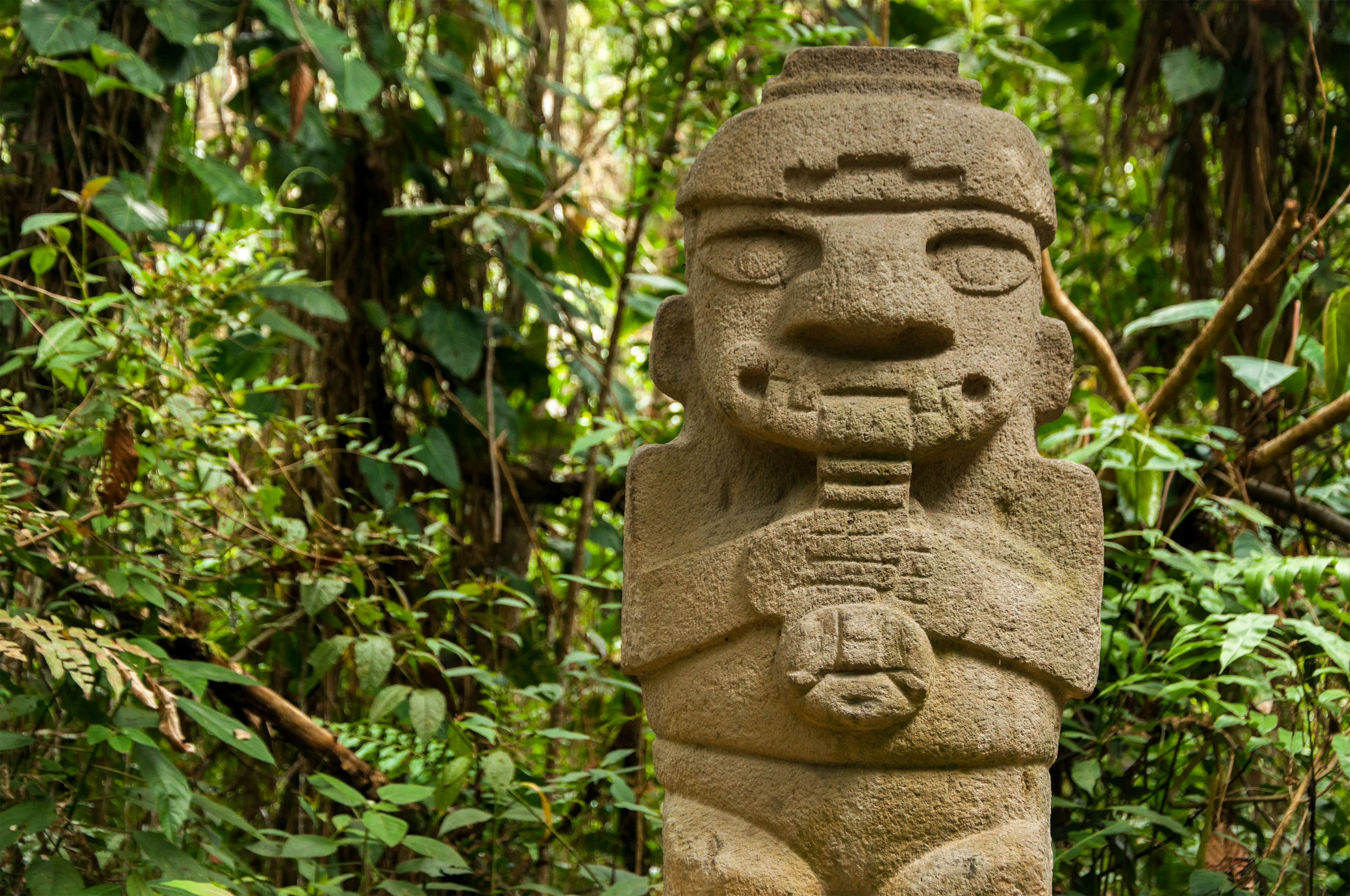 A pre-Columbian stone figure of a flute-playing person at Parque Arqueológico San Agustín, Colombia